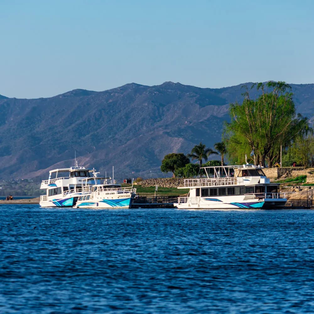 Recorrido del City Tour Lacustre con agua calma y sierra al fondo